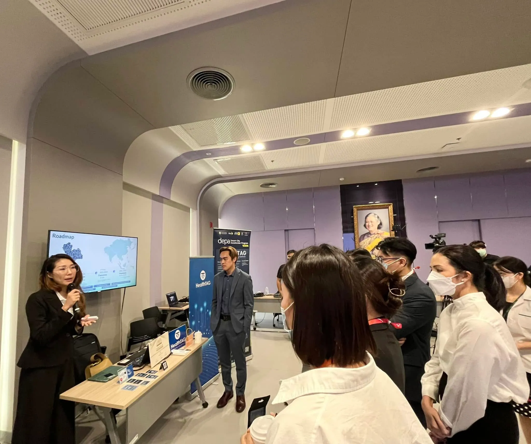 Centre for Health Innovation Fellowship participants listen to a HealthTAG demonstration beside the display table