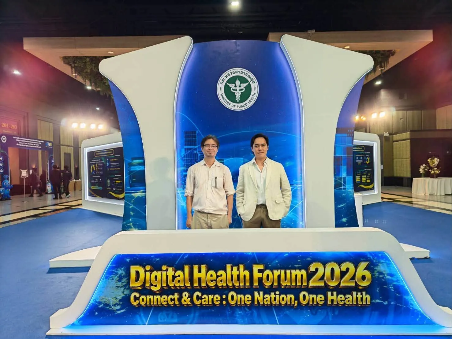ผู้ร่วมจัดแสดงสองคนยืนหน้าป้าย Digital Health Forum 2026 ที่บูธกระทรวงสาธารณสุข