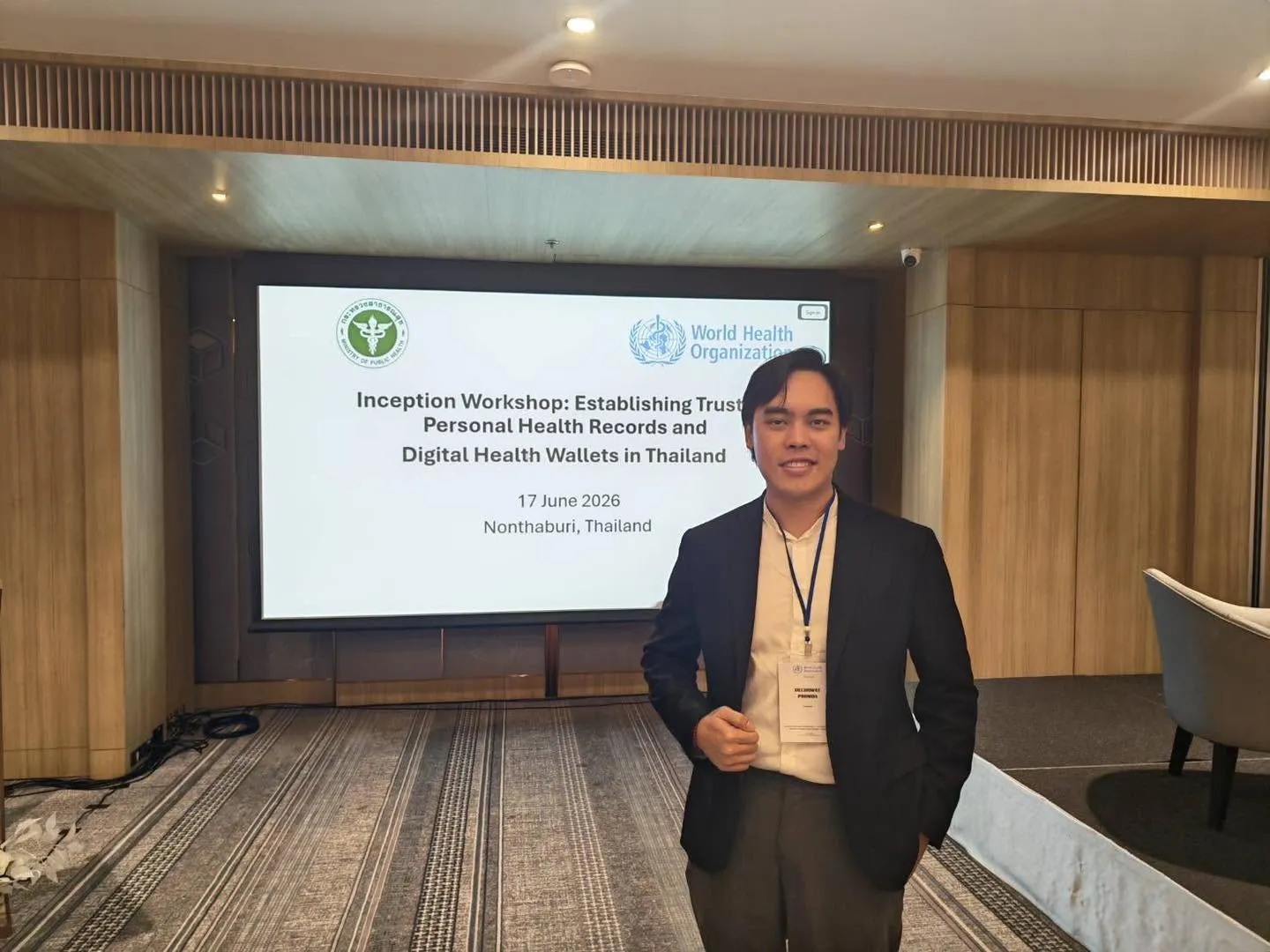 ผู้เข้าร่วมงานยืนหน้าจอชื่องาน Inception Workshop: Establishing Trusted Personal Health Records and Digital Health Wallets in Thailand